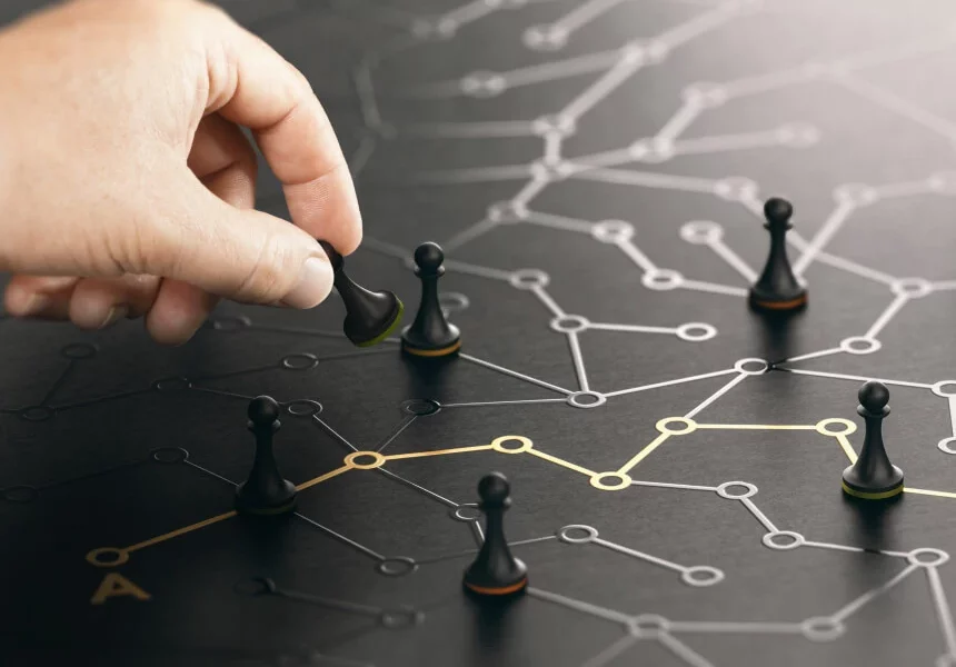 Dłoń umieszczająca pionka w złożonej, ciemnej sieci połączonych punktów danych i relacji, stanowiąca metaforę ujednoliconego profilu klienta i platformy Customer Data Platform.